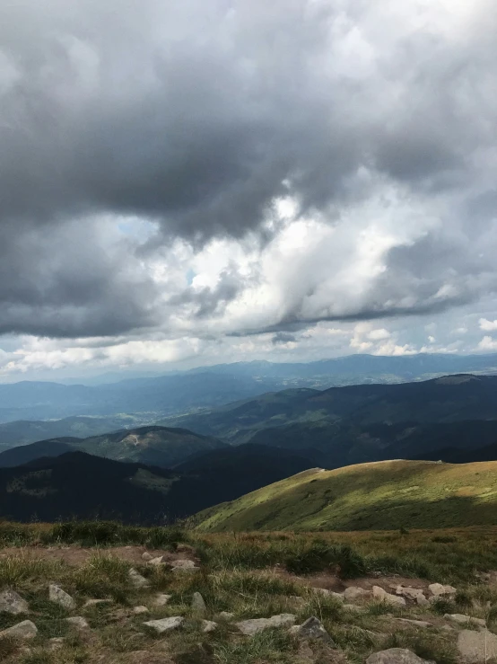 some hills and trees with some clouds above