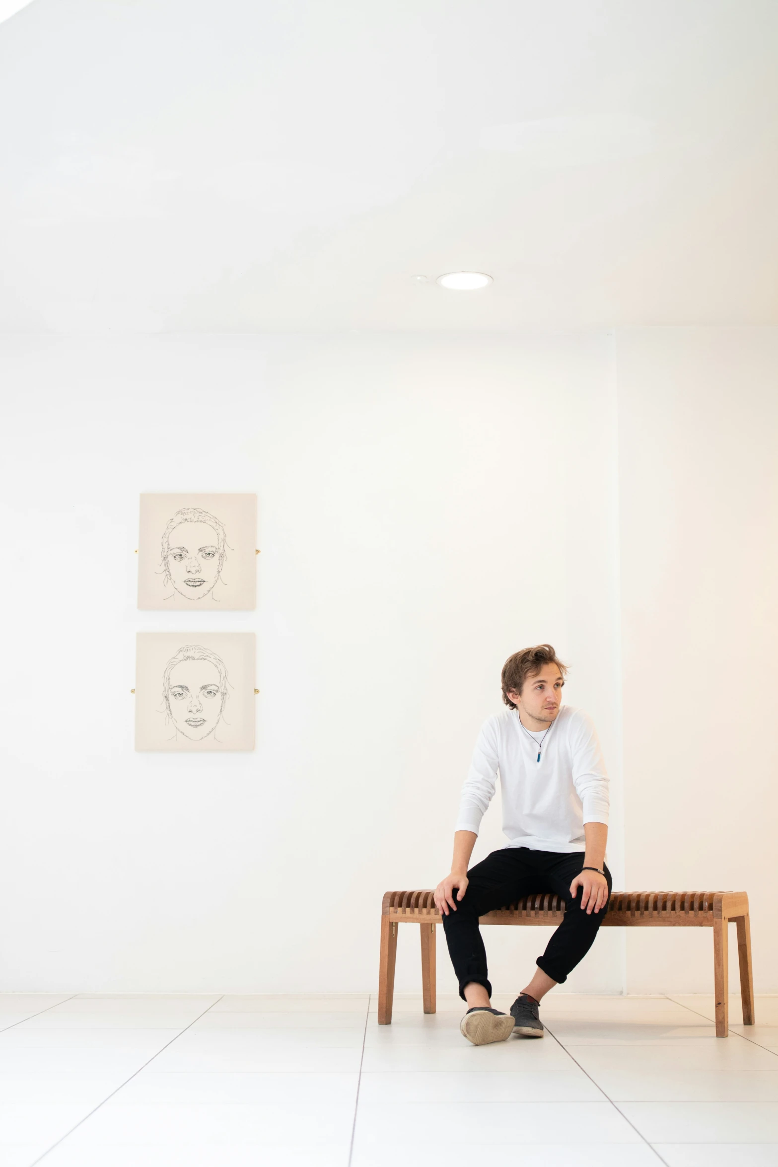 a man sitting on a bench in an empty room