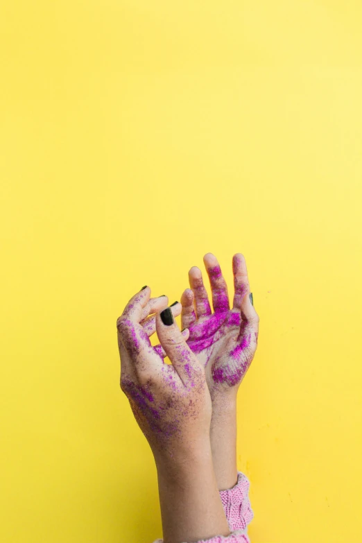 a girl with her hands on her face painted with colors