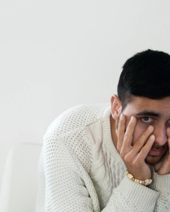 a young man looks over his right shoulder