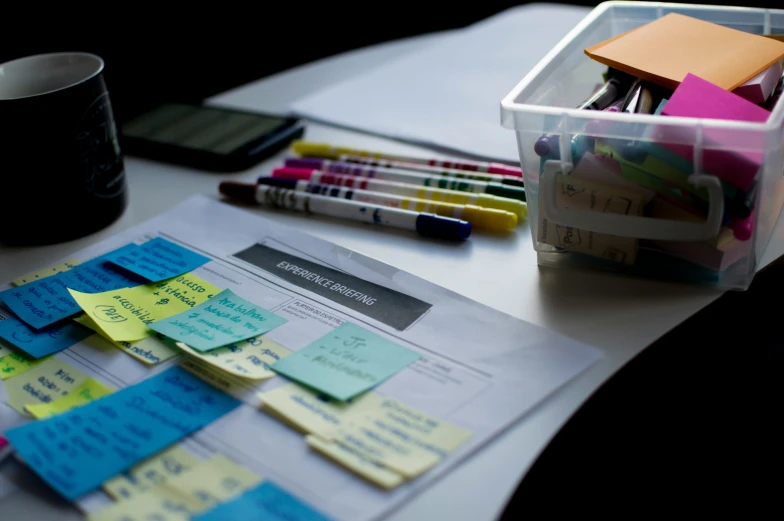 a desk has sticky notes and a pen