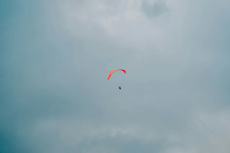 a parasailer sails through the sky on a gloomy day
