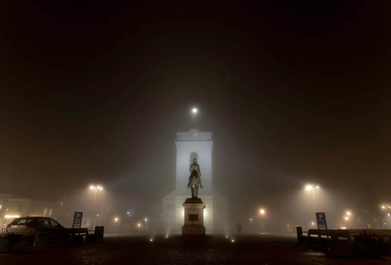 the statue stands alone in the fog on a dark street