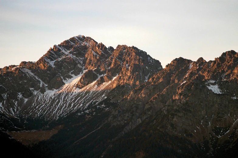 a snowy mountain range during the sunset with snow on the mountains