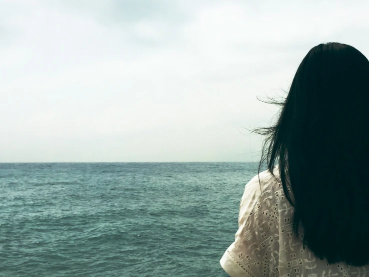 back of the person looking out on the ocean from a boat