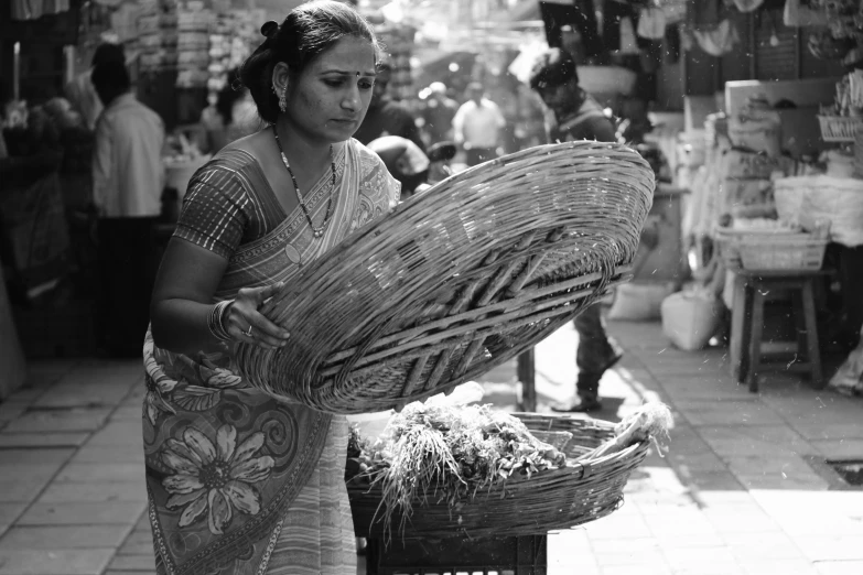 a woman holding out baskets in a market area