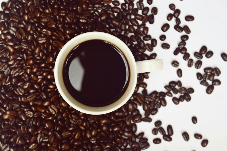 an overhead view of coffee beans and one cup