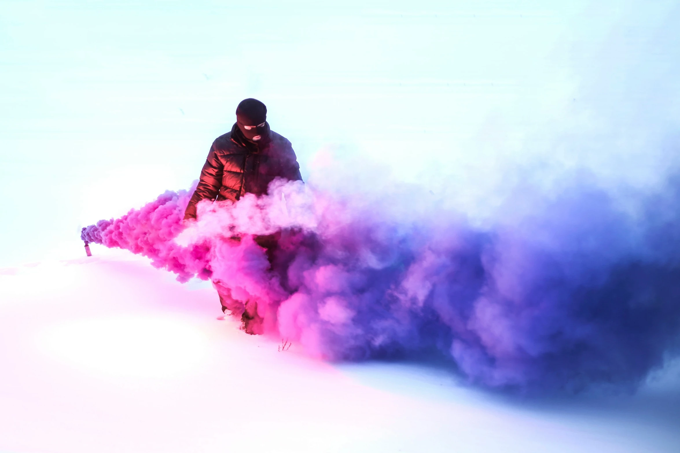 a man riding skis covered in pink smoke