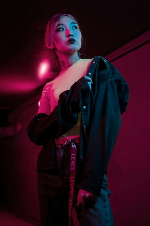 a woman in dark clothes poses at night