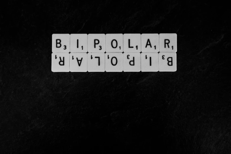 three black and white tiles with letters are on a black background