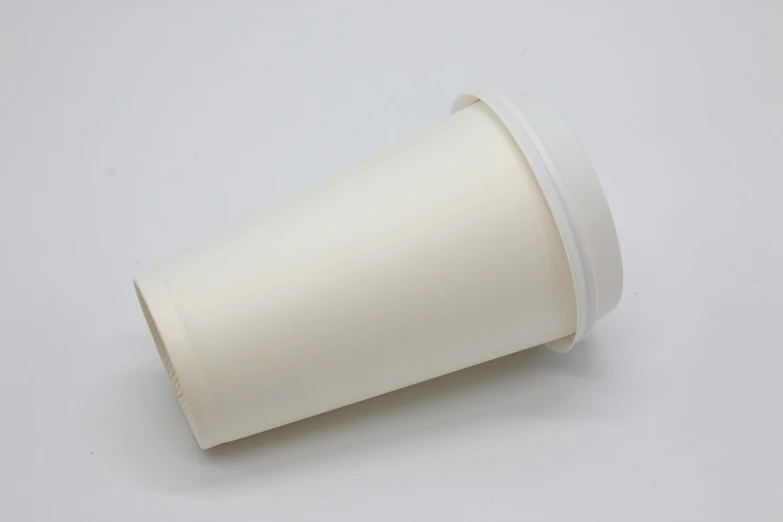 a white cup with an inner ring sits on a table