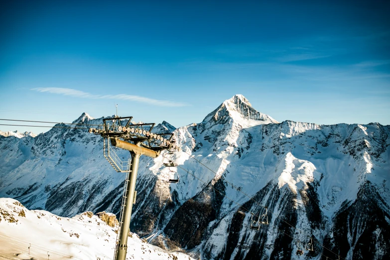 a ski lift on a snowy mountain with clear sky