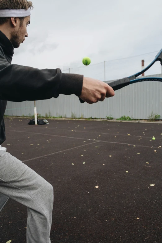 a man holding his tennis racket in one hand and about to swing at the ball