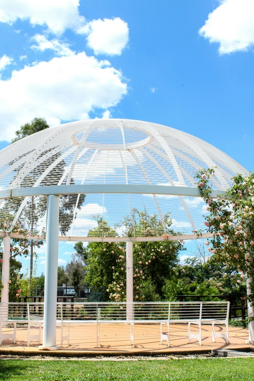 a large metal structure on a field with trees