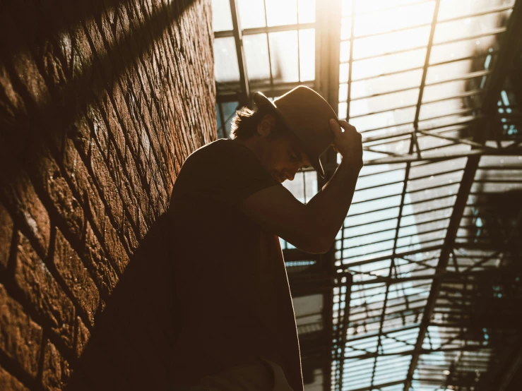 man standing next to a wall looking off in the distance