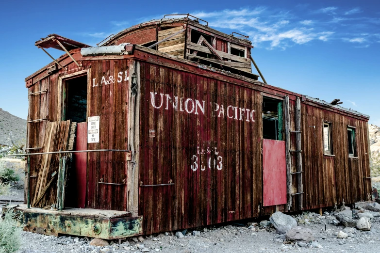 an old abandoned red train sitting in the desert