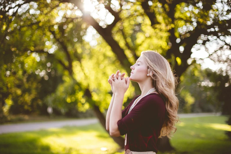 young woman blowing bubbles in park on a sunny day