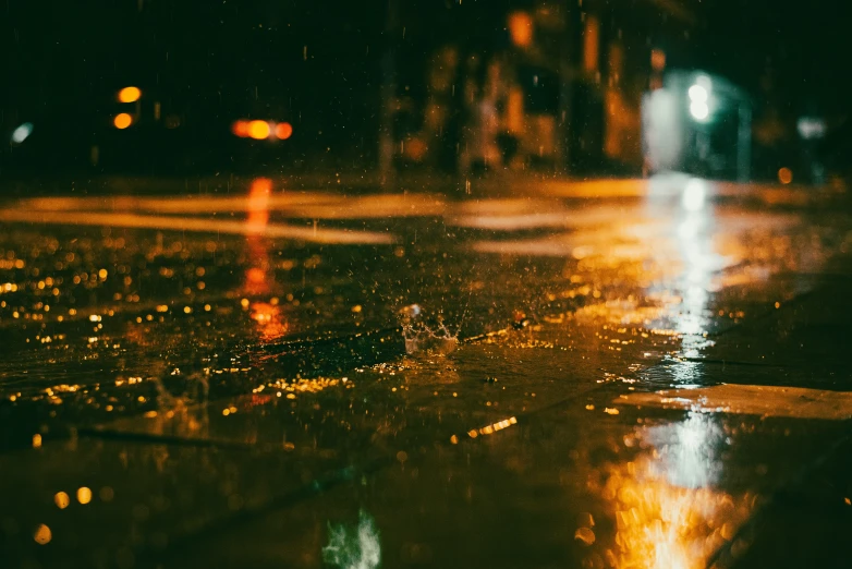 it is night time and rain falling down on the street