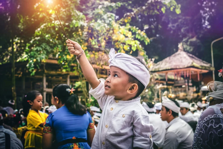 a child in white is holding up soing