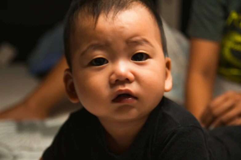 a little boy is sitting on the floor and looking at soing