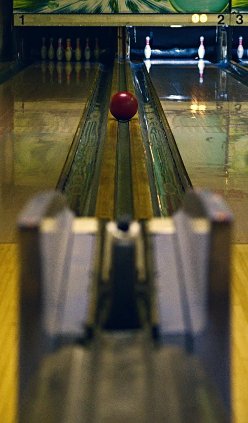 a bowling ball sits in front of a line of pins