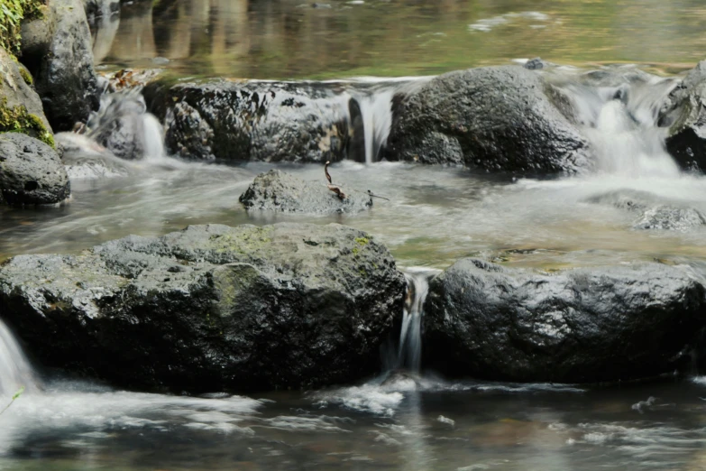 there are several rocks on the river with water