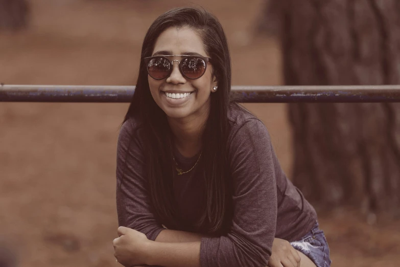 a woman with glasses leaning against a bar