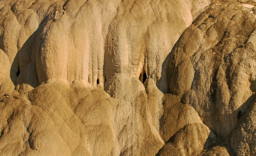 a large group of rock formations towering over a field