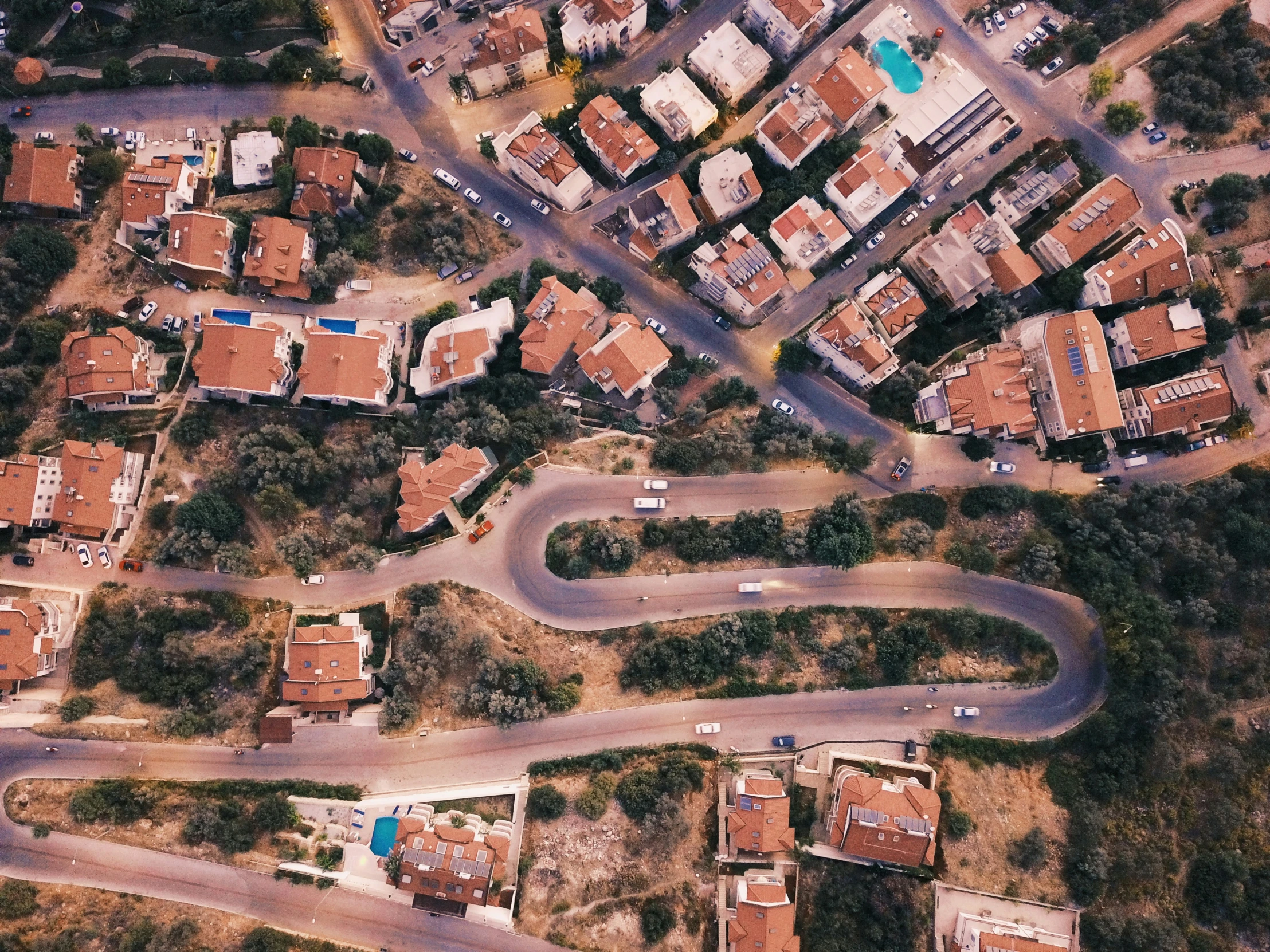 an overhead view of a road surrounded by a lot of houses