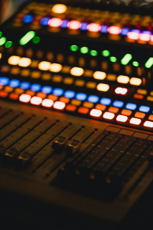 a sound mixing console with lots of colored lights