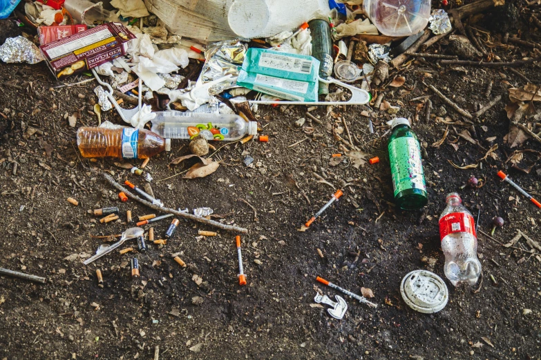 an unopened bottle, cigarettes, and other objects are on the ground