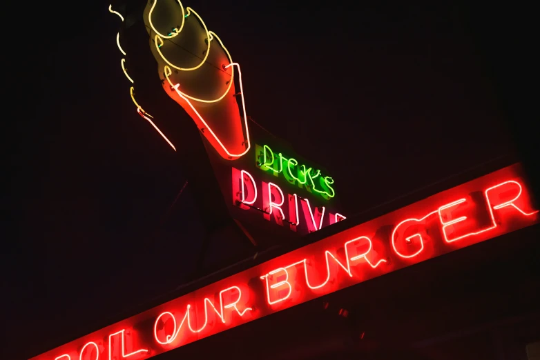 the neon sign has an alien on top