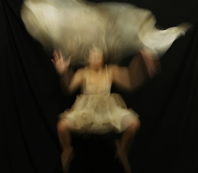 the blurry image shows a blurred image of a girl sitting in a chair with her arm extended