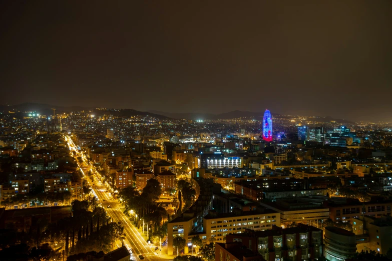 a view from the top of a building shows buildings in lights and tall buildings