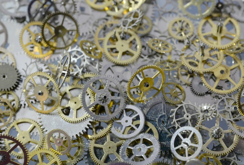 a table covered with lots of silver and gold gears