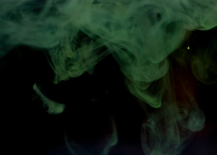 closeup of an abstract, swirling background with green and white smoke