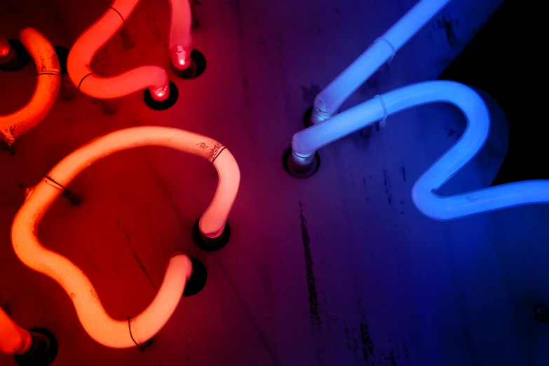 neon lights on a wall with several tube light up the room
