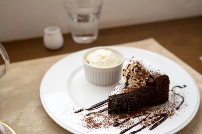 a chocolate slice of cake and whipped cream on a plate