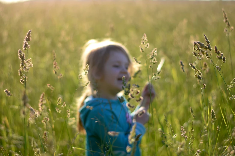 a little girl is in a grassy field