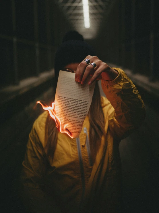 person with hand over open book near tunnel