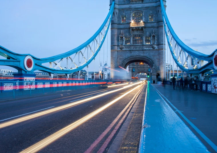 the tower bridge is lit up at night