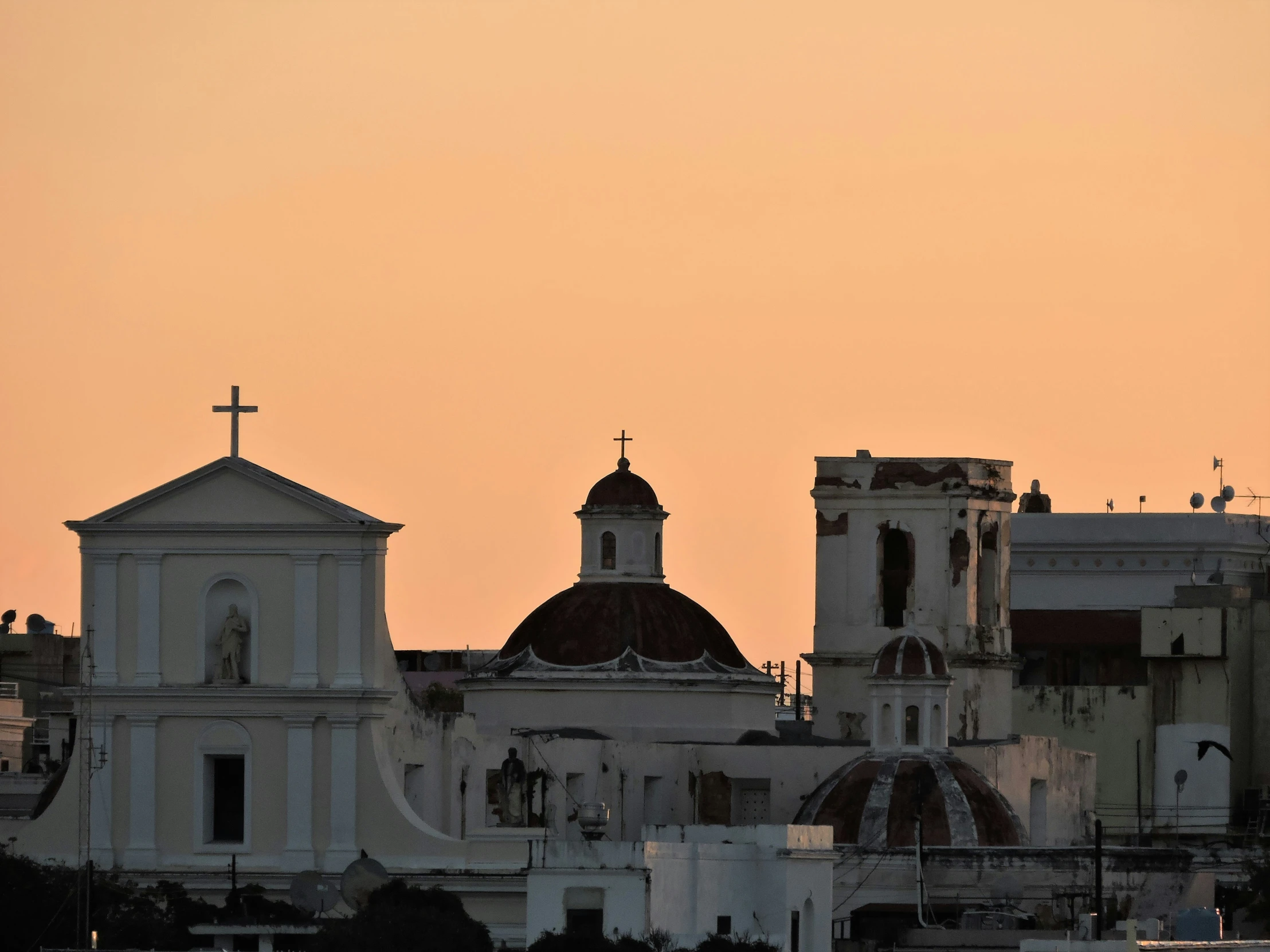 the silhouette of the church towers against a peach colored sky