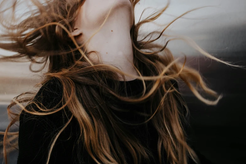 a woman with long, flowing hair blowing in the wind