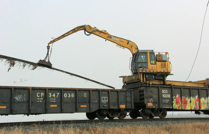 a large yellow bulldozer is traveling down the railroad tracks