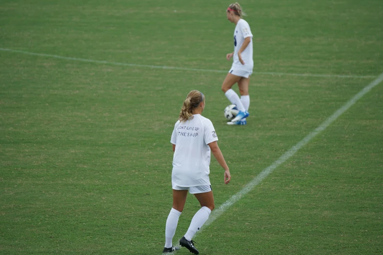 two soccer players standing on the side of a field