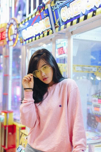 an asian woman in a pink sweater looking away from the camera