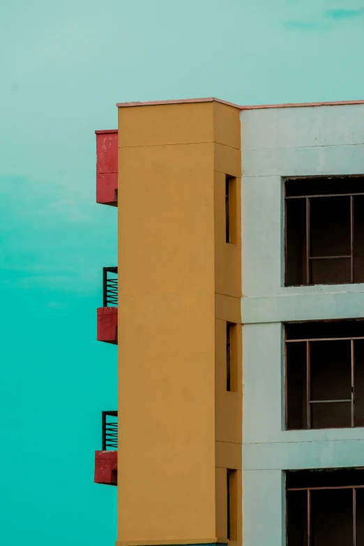 a yellow building with several windows in front of a blue sky