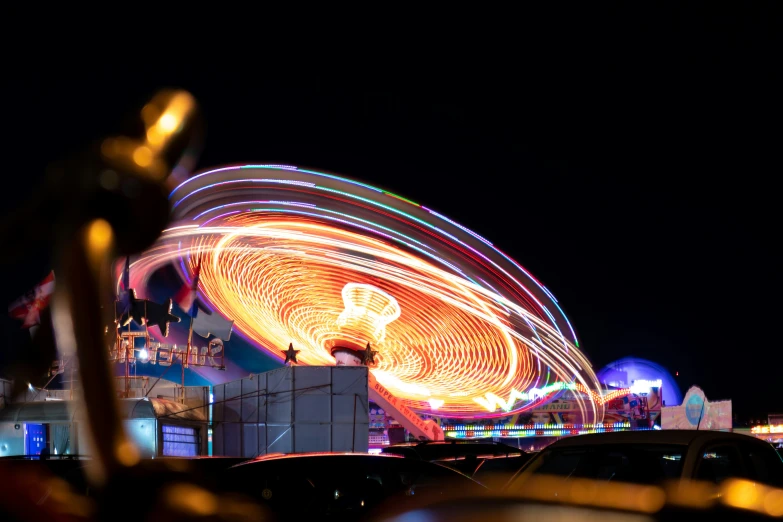 a carnival ride spinning on top of it with blurry lights