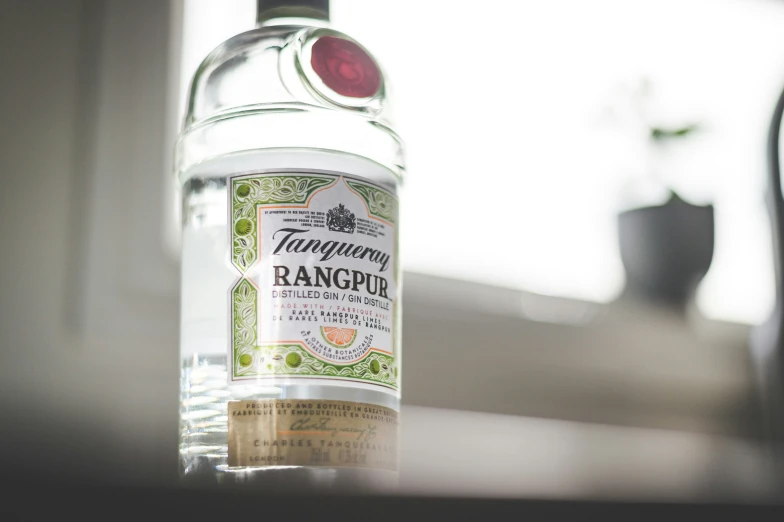 a bottle with a red lid sitting on a window sill