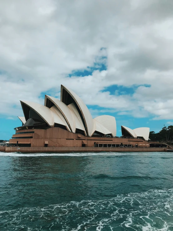 a boat traveling past the opera house